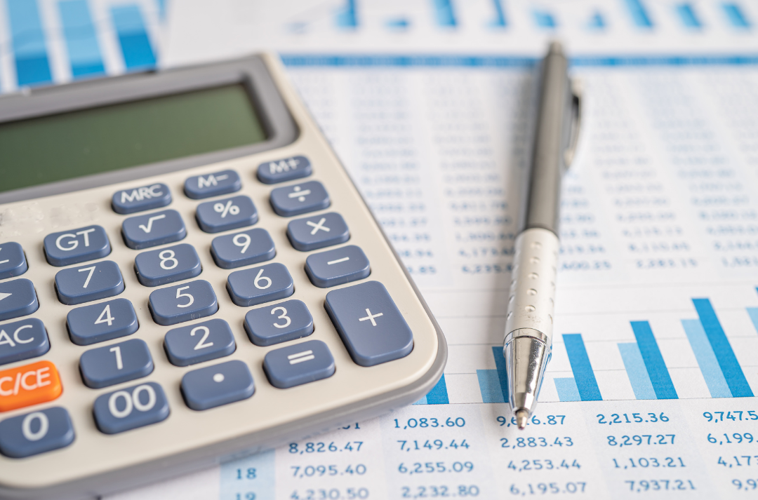 Calculadora, caneta e planilhas financeiras representando a análise de viabilidade técnica e financeira